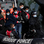 Människor som försökt korsa Engelska kanalen i en liten båt grips av gränspolis i Dover 17 juni 2022.  Matt Dunham / AP