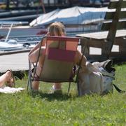 Solande människor vid en båtbrygga vid Mälaren