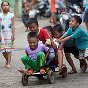 Barn leker på en cykel i Indonesien.