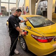En taxichaufför tankar sin bil i Ardakan i Iran tidigae i höst.