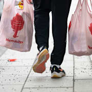 En man bär hem livsmedel i två matkassar. Arkivbild. 