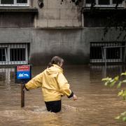 En kvinna vandrar igenom översvämmade Liege i Belgien den 15 juli.