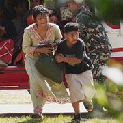 Soldater hjälper en familj ur en helikopter efter att de räddats från ett översvämningsdrabbat område i distriktet Nuwakot i Nepal.
