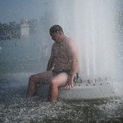 En person svalkar sig i Trocadero-fontänen i Paris.