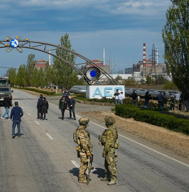 FILE - Russian servicemen stand on the road towards the Zaporizhzhia Nuclear Power Station in territory under Russian military control, southeastern Ukraine, May 1, 2022. AP