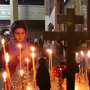 En flicka tänder ett ljus under det ortodoxa julfirandet i Ryssland förra året. Musa Sadulayev / AP