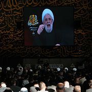 Naim Qassem syns på en skärm under en religiös högtid vid tidigare Hizbollahledaren Hassan Nasrallahs grav.
