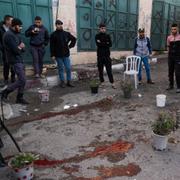 Palestinier står samlade runt ett blodstänk efter en israelisk militärräd på Västbanken den 12 december. 