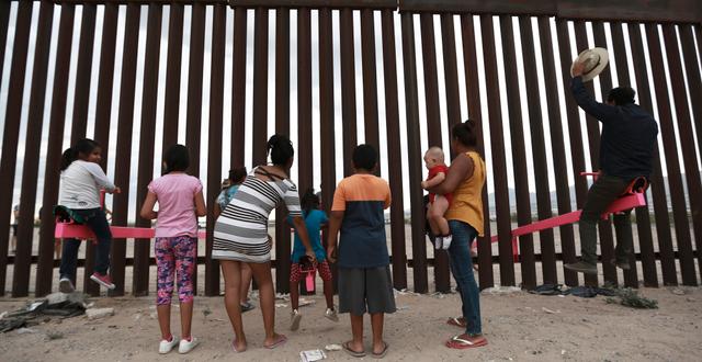 Familjer står vid gränsen mellan USA och Mexiko.  Christian Chavez / TT NYHETSBYRÅN/ NTB Scanpix