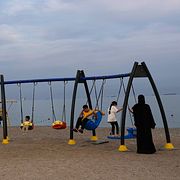 Barn leker i Förenade Arabemiraten, med Hormuzsundet i bakgrunden.
