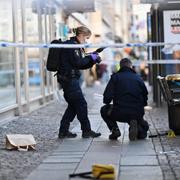 Polisens kriminaltekniker undersöker ett avspärrat område efter händelsen.