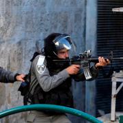 En israelisk gränspolis riktar sitt vapen under protester i Hebron på måndagen.