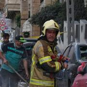 Brandmän och civila röjer upp i Teheran efter en israelisk attack i natt.