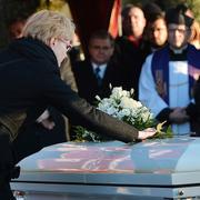 Lukasz Urbans änka lägger blommor på hans kista under ceremonin i polska Banie.