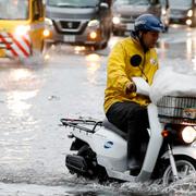 Man försöker ta sig fram på moped i Tokyo under måndagsmorgonen. 