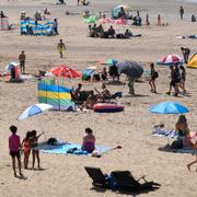 Badgäster vid Camber Sands i södra England.