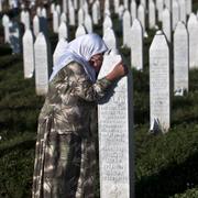 Arkivbild: En kvinna gråter vid en av gravarna vid minnesplatsen i Potocari utanför Srebrenica.