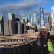 En kvinna går på Brooklyn Bridge i New York.