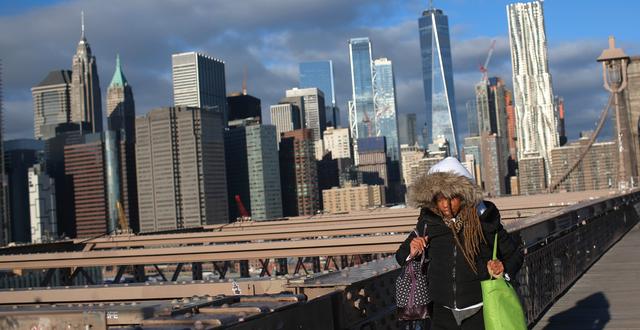 En kvinna går på Brooklyn Bridge i New York. Wong Maye-E / AP