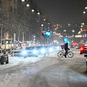 Biltrafik och cyklist på snötäckt gata på Södermalm i Stockholm på fredagen.