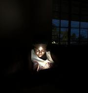 En ung flicka använder solenergi för att ladda sin telefon. Tsvangirayi Mukwazhi / TT NYHETSBYRÅN