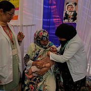 En sjukvårdare ger poliovaccin till ett litet barn i Kashmir. Bild från 28 juni.