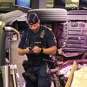 En polis på plats inne i gymlokalen efter att en bil kraschat rakt in.