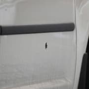 Hål i en bil på den plats i centrala Helsingborg där flera personer skadats i en skottlossning under lördagskvällen.  