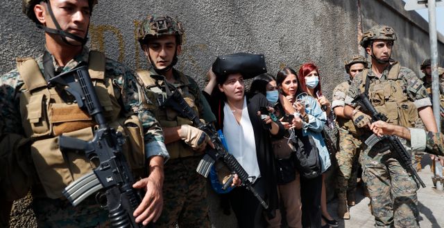 Soldater skyddar en grupp lärare vid en skola i Beirut på torsdagen. Hussein Malla / TT NYHETSBYRÅN