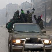 Regimtrogna passerar flyende civila i östra Aleppo, 13 december.