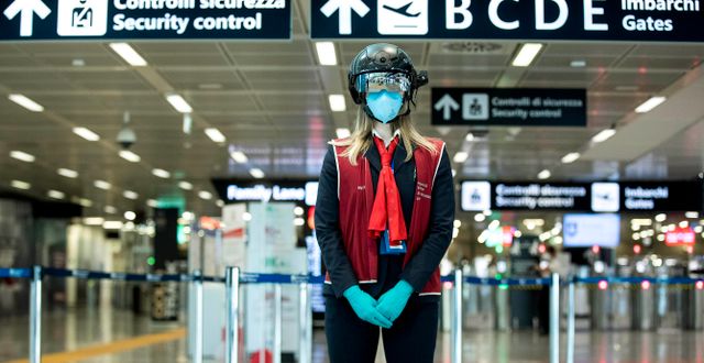 En anställd bär en ”smart hjälm” som ska skanna av kroppstemperaturen hos resande på flygplatsen i Rom i början av maj. Roberto Monaldo / TT NYHETSBYRÅN