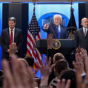 Lastbilar står på rad vid en hamn i Kalifornien på fredagen/Donald Trump svarar på frågor om sin tullpolitik.