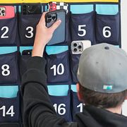 Elev lägger sin mobiltelefon i ett avsett fack inför en lektion i Delta, Utah, 2024. 