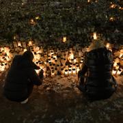 Människor tänder ljus på minnesplatsen utanför Campus Risbergska i Örebro där tio personer dog i en skolskjutning.