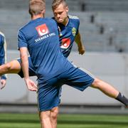 Viktor Claesson och Sebastian Larsson stretchar under tisdagens träning på Friends Arena med herrlandslaget inför de kommande EM-kvalmatcherna mot Malta och Spanien.