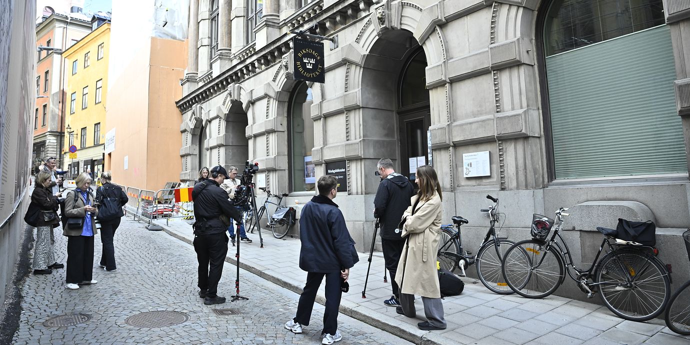 Journalister utanför Vänsterpartiets riksdagskansli i Gamla stan i Stockholm.