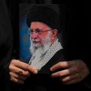 En kvinna som håller upp ett fotografi på Ali Khamenei under en demonstration. 