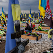 En kvinna sörjer vid sin väns grav i östra Ukraina. Bernat Armangue / AP