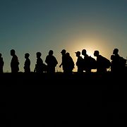 Migranter som korsat gränsen köar för att komma in i USA.  Eric Gay / AP