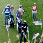 USA:s Tony Finau vinkar till publiken medan Europas Padraig Harrington, Jon Rahm, Sergio Garcia och Henrik Stenson ser på.