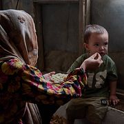 En kvinna matar ett barn i sitt hem i Kabul.