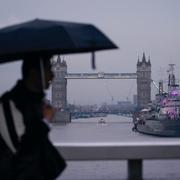 En person med paraply passerar framför Tower Bridge i London. Bilden är tagen tidigare i veckan. 