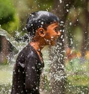En pojke svalkar sig under värmeböljan i Asien. Rajesh Kumar Singh / AP