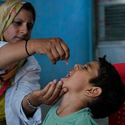En sjukvårdare ger ett barn i Kashmir poliovaccin. Bild från 28 juni.