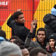 Migranter köar till bussarna som ska ta de ifrån ”djungeln” i Calais.