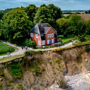 Huset nära Travemünde i Tyskland har stängts av efter att marken eroderat bort allt närmare huset, något som tros bero på klimatförändringarna. 