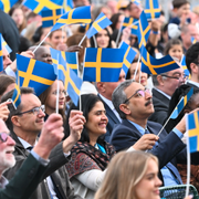 Håkan Hellström och publik med svenska flaggor under nationaldagsfirande på Skansen i Stockholm 2024. 