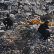 Två människor sitter i förödelsen i Gaza stad i norra delarna av området på lördagen. 