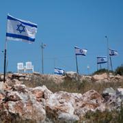 Isrealiska flaggan vajar på den ockuperade Västbanken, i närheten av en nyligen attackerad palestinsk by, rapporterar AP.