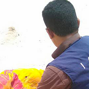 En IOM-medarbetare och en död kropp som spolats upp på stranden i Jemen efter gårdagens händelse.